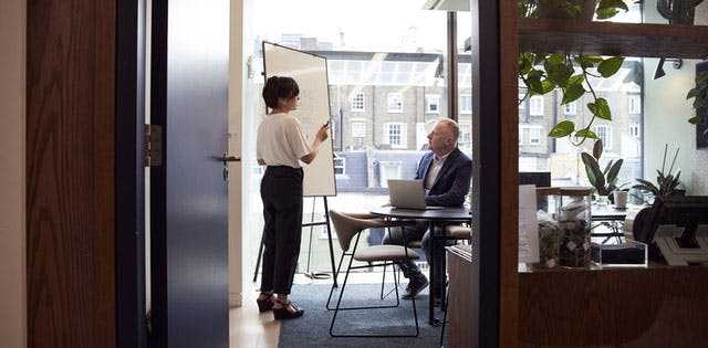 Beraterin präsentiert vor einem Team